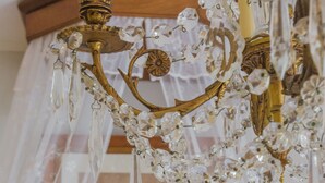 A chandelier with crystal decorations and a framed picture on the wall.