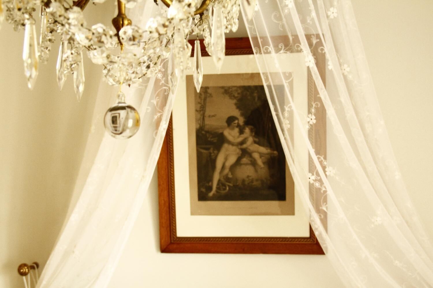 Fotografía enmarco con estilo vintage, colgada en una pared bajo un candelabro decorativo.