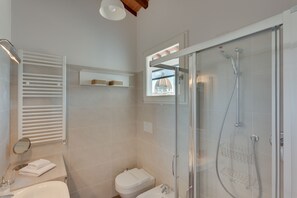 A modern bathroom with a glass-enclosed shower, a toilet, a sink, and a towel rack. - Rondinelli Terrace (Florence)