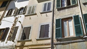 Un edificio con varias ventanas y un toldo verde con el letrero "la tua Edicola".