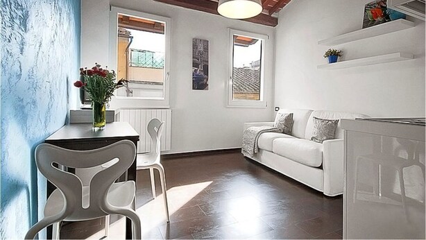 Un espacio habitable compacto con comedor, sofá y kitchenette.
