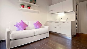 A modern kitchen with white cabinets, a white countertop, and a wooden ceiling. - San Gallo Suites III (Florence)