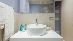 A modern bathroom with a large white sink, a mirror, and a towel rack. - San Lorenzo Chic (Florence)