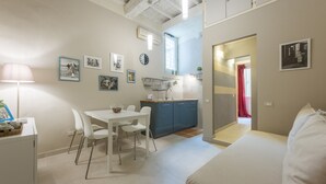 A compact living space with a dining area, kitchenette, and a bed. - San Lorenzo Chic (Florence)