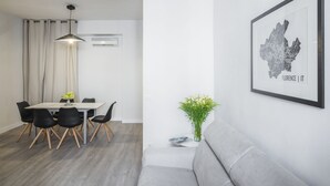 A modern dining area with a white table, black chairs, and a hanging light fixture. - Sant’Ambrogio Passion (Florence)