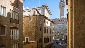 A historic square with a prominent clock tower, surrounded by traditional buildings with balconies and windows. - Santa Maria View (Florence)