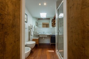 A compact bathroom with a toilet, bidet, sink, and mirror. - Santo Spirito Charme (Florence)
