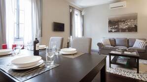 A dining area with a table set for four, a sofa, and a coffee table. - Stylish Anguillara (Florence)