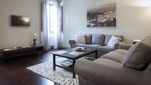 A modern living room with a sofa, coffee table, and TV. - Stylish Anguillara (Florence)