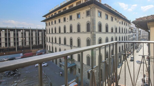 A hotel with a large, multi-story building featuring arched windows and a flat roof. - Unità Balcony (Florence)