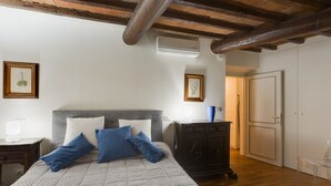 Un dormitorio con cama, cómoda, mesita de noche y puerta.