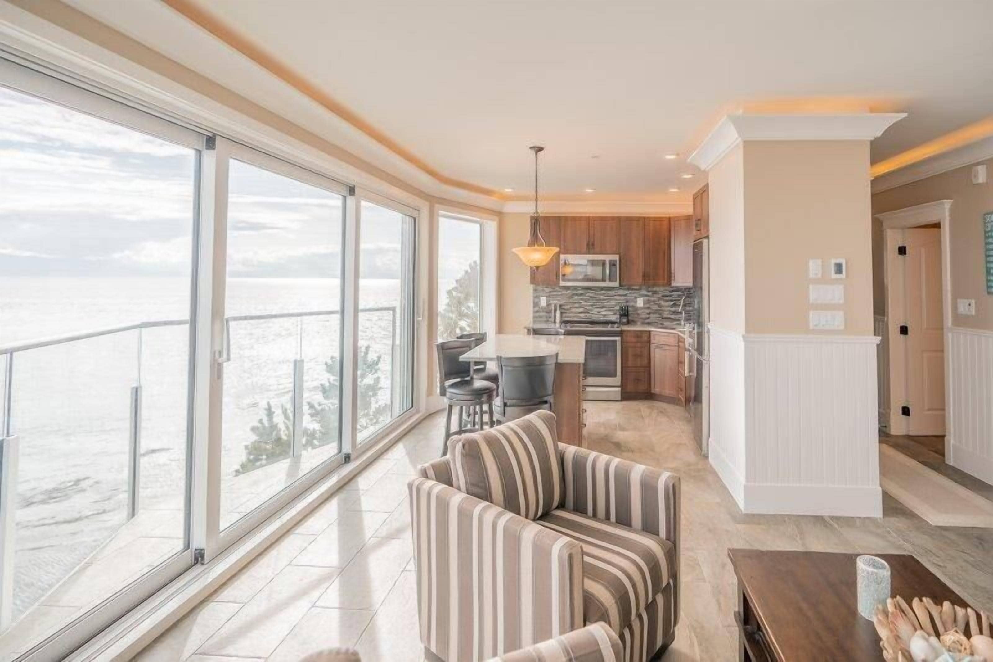 Un interior moderno con cocina, comedor y un amplio ventanal con vistas panorámicas.