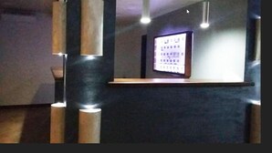 A reception area with a digital display, a reception desk, and vertical wooden columns. - Suite Hotel Club Dominicus (Grisolia)