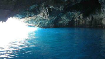 Una grotta naturale con acque cristalline blu e pareti rocciose.