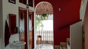 A bathroom with a sink, mirror, and a red wall. - Hotel La Union (Flores)