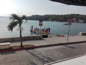 Un muelle con gente y una señal de parada.