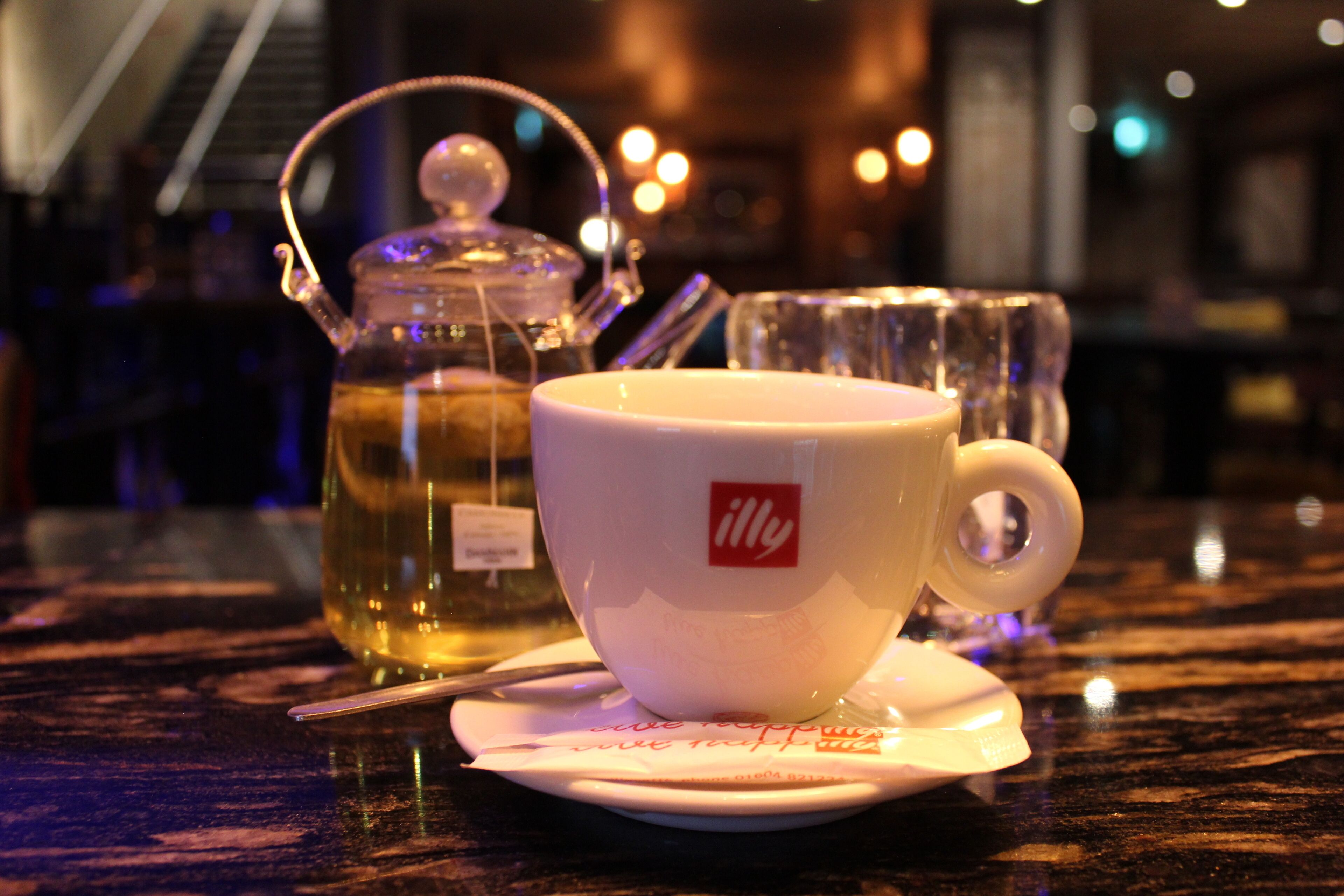 A table with a teapot, a cup, and a saucer.