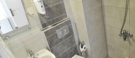 A bathroom with a sink, toilet, and shower.
