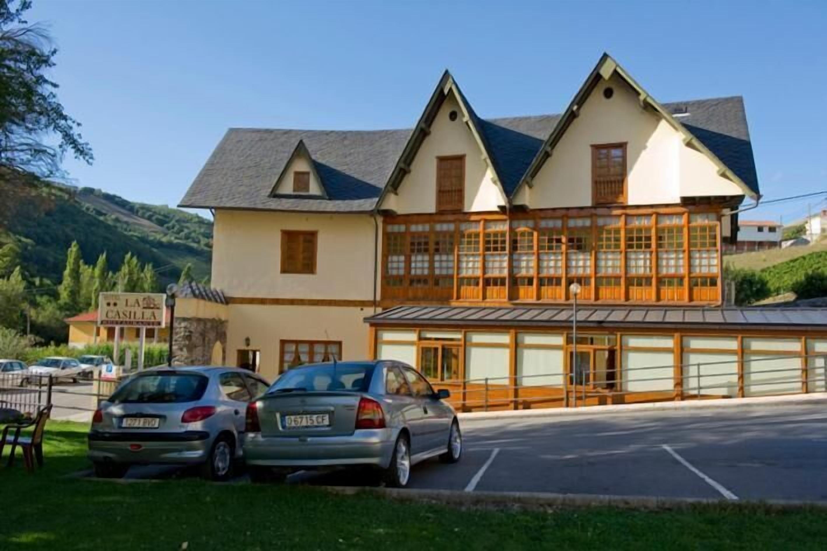 A two-story building with a traditional architectural style, featuring a large windowed section on the ground floor.