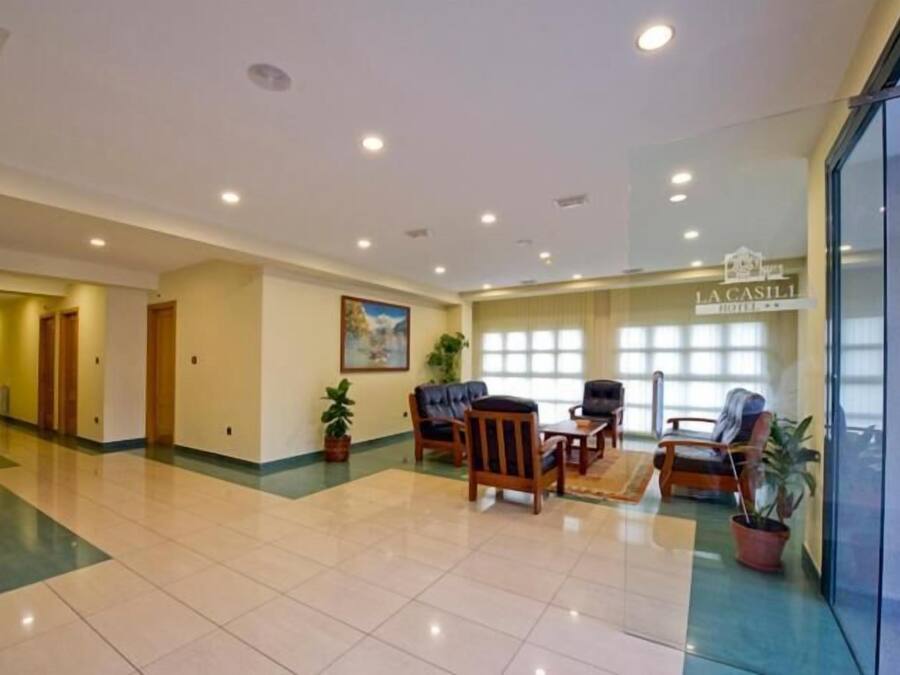 A hotel lobby with a reception desk, seating area, and a large window.