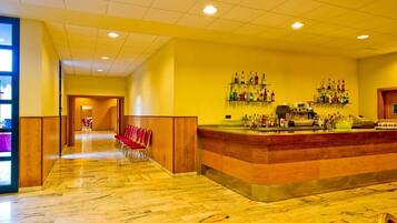 Un hall d’hôtel avec un sol en marbre, un comptoir d’accueil et un espace bar.