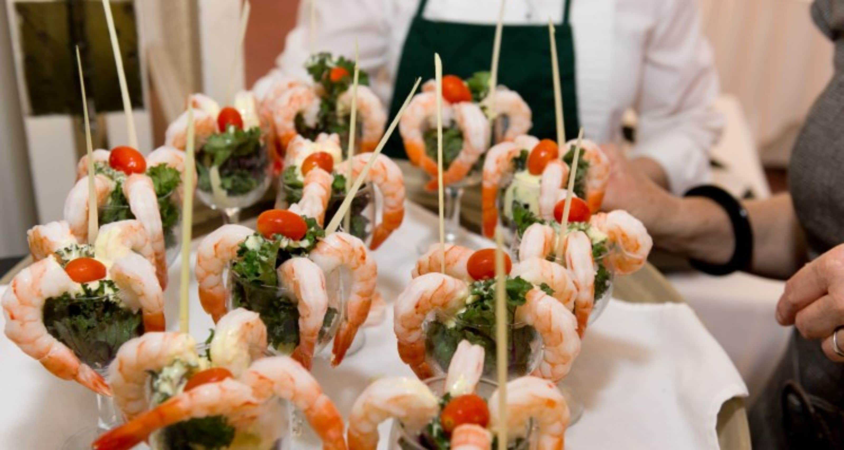 Une table avec des brochettes de crevettes et de légumes.