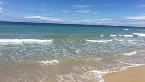 Ein Strand mit klarem, blauem Wasser und einem Sandufer.