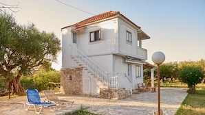 Ein zweistöckiges Haus mit einer Stein-Fassade, einer Treppe und einem Balkon.