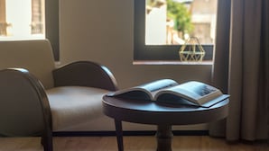 A modern room with a round table, a chair, and a window with curtains. - Hotel Casa Peya - Adults Only (Palafrugell)