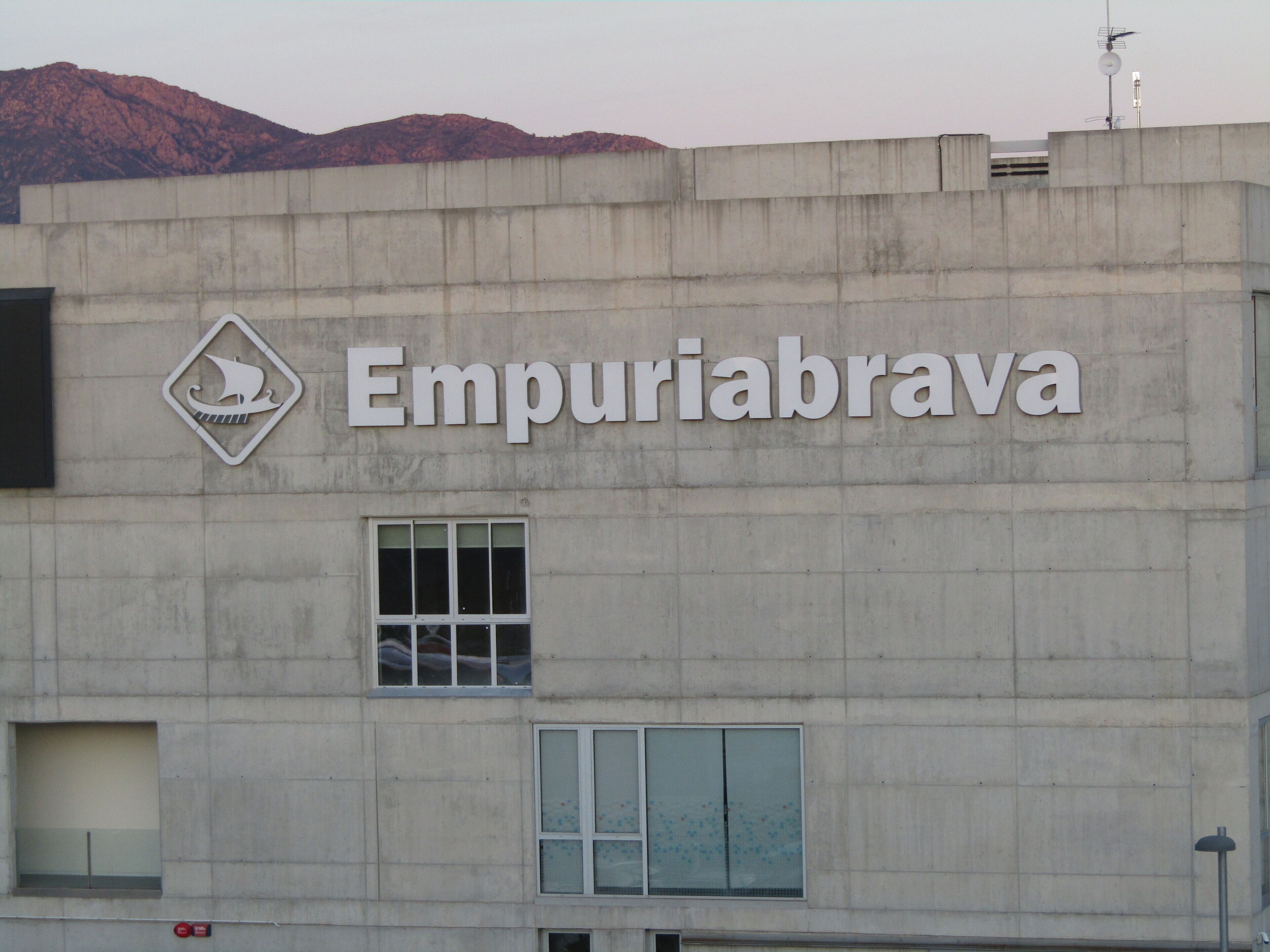 Un edificio con el nombre "Empuriabrava" y un logotipo de velero.