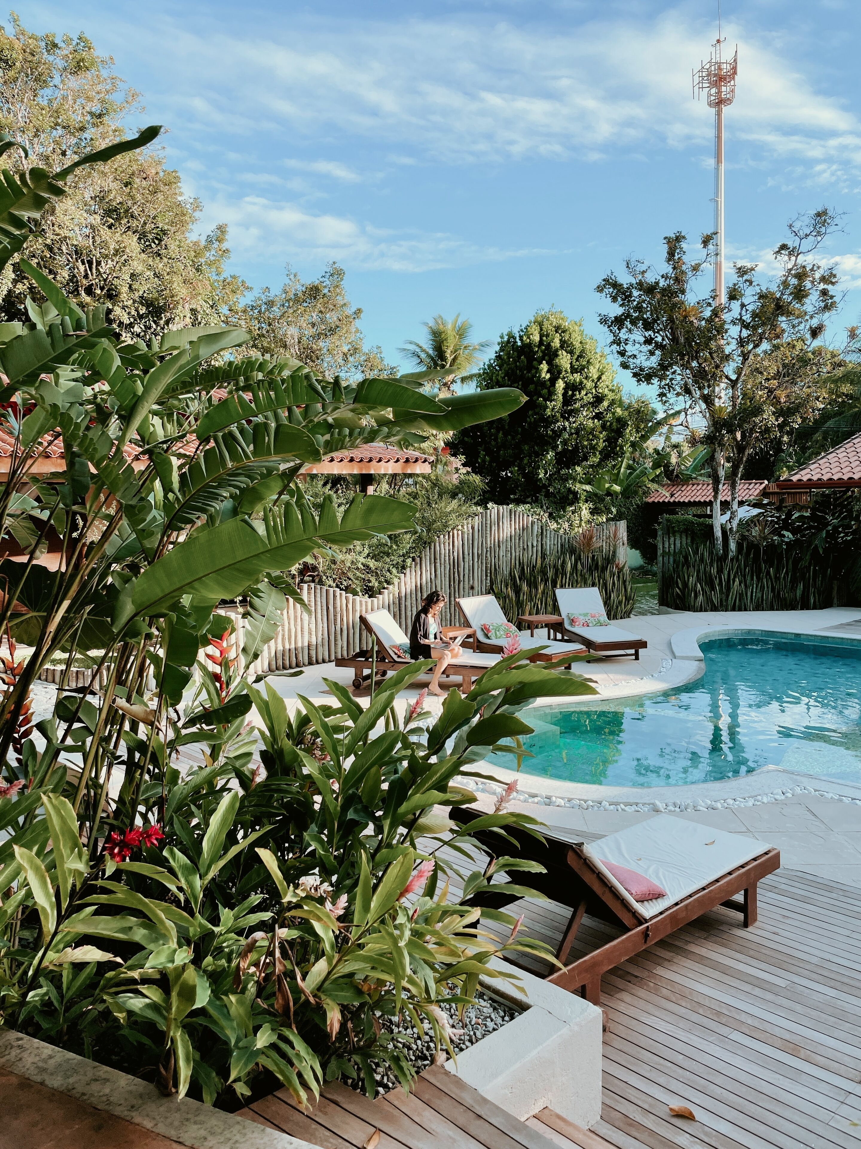 A pool area with lounge chairs and a wooden deck.