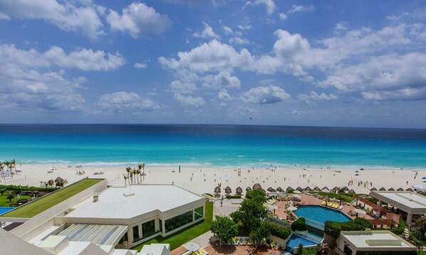 A resort with a pool, beach, and ocean view.
