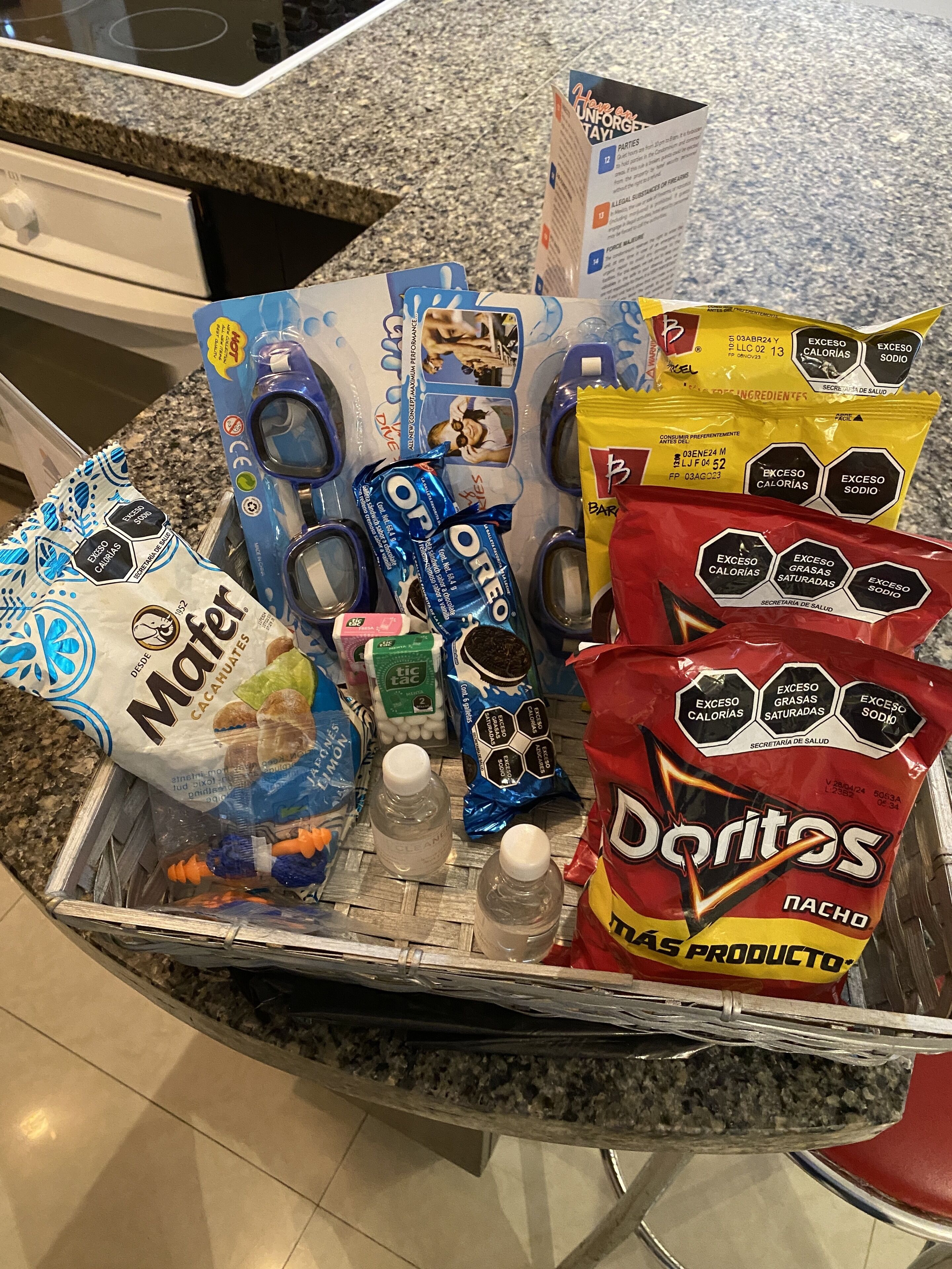 A kitchen counter with various food items including chips, cookies, and a bag of Doritos.