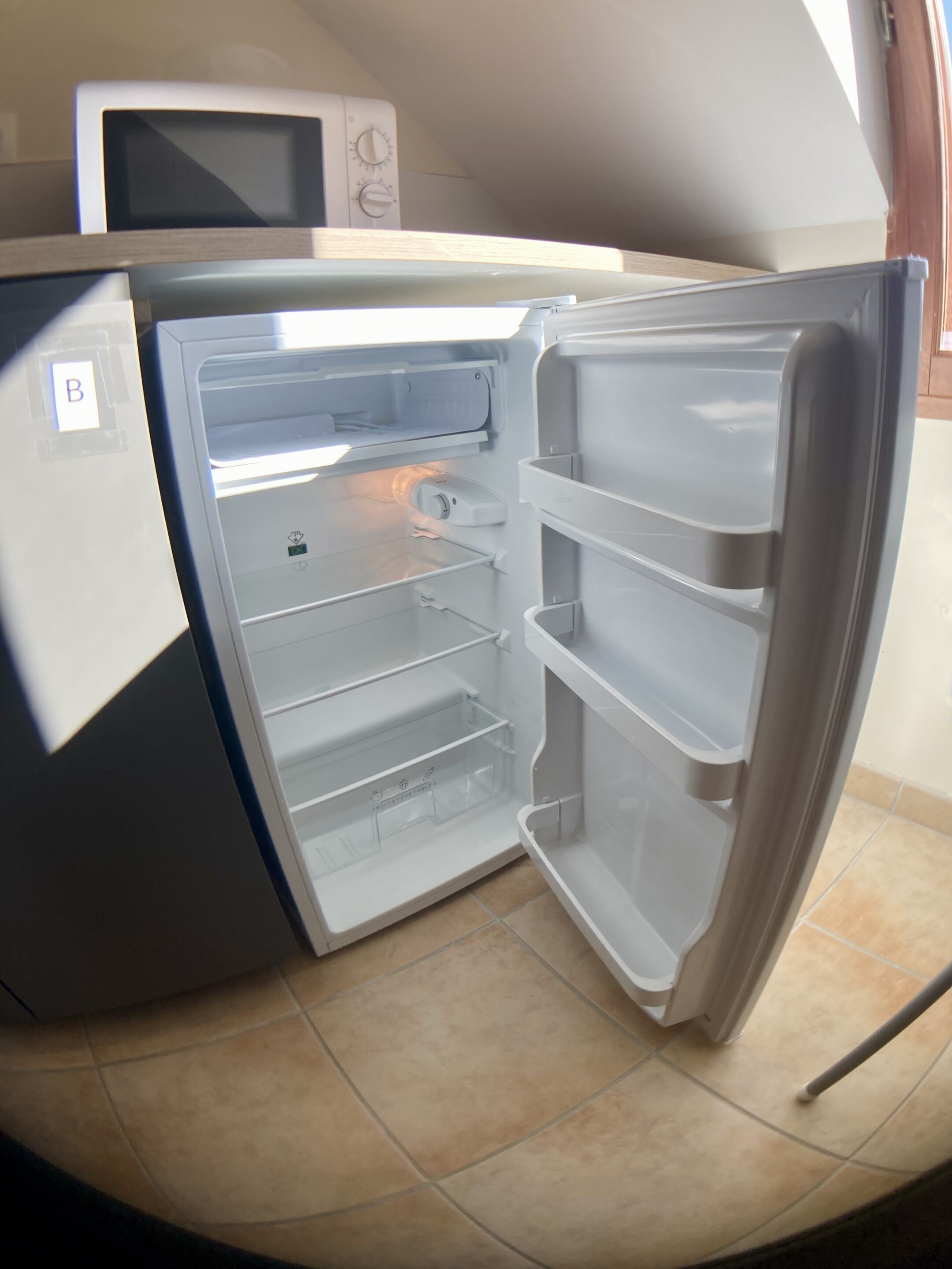 Un refrigerador abierto con múltiples estantes y un compartimento congelador.