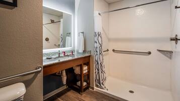 A modern bathroom with a shower, a sink with a marble countertop, and a towel rack.