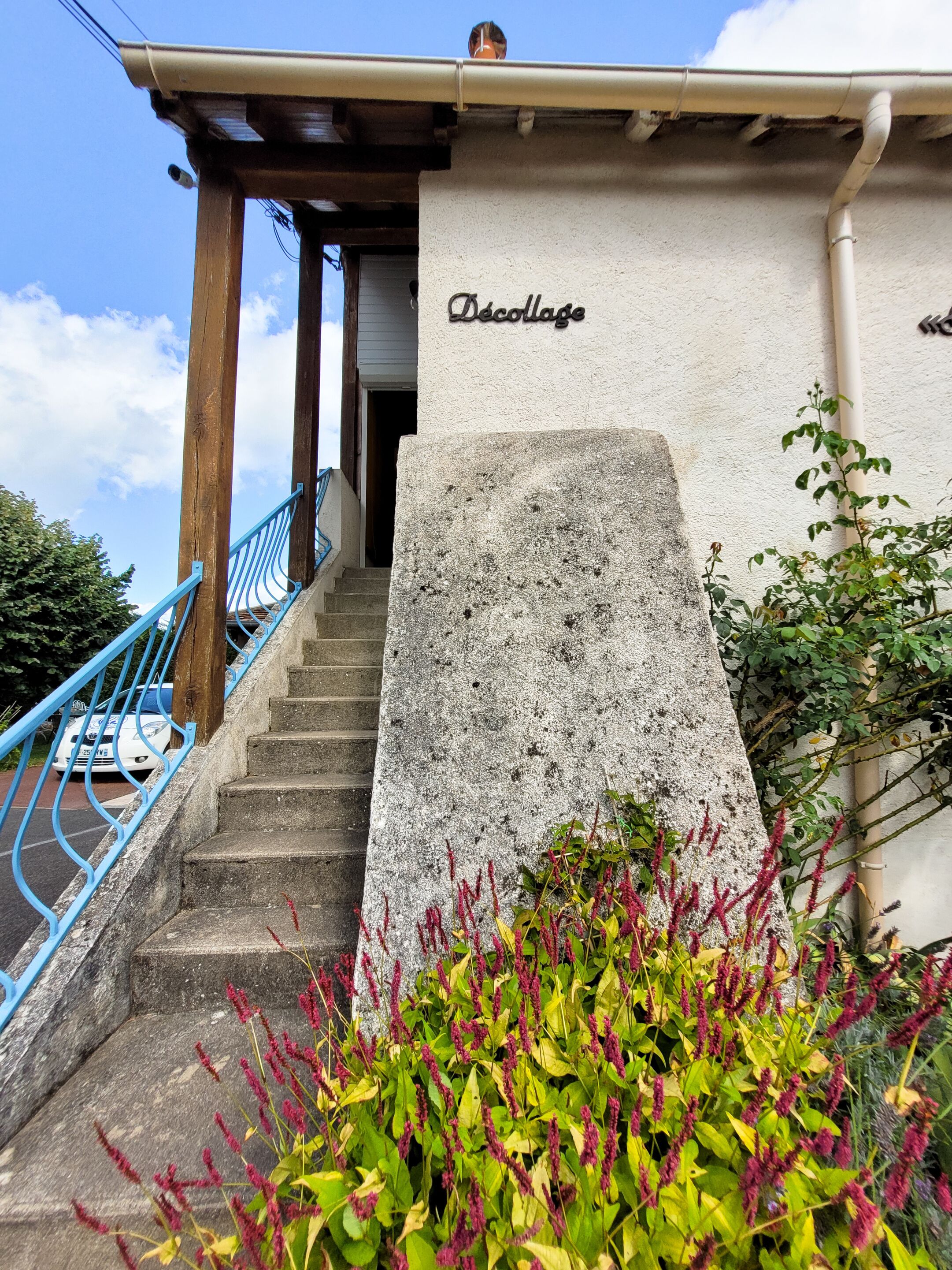 Un escalier en pierre menant à un bâtiment portant l’inscription « Décollage ».