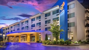 A hotel with a modern design, featuring a prominent blue and white color scheme, multiple floors, and a well-lit entrance. - GLō Hotel Asheville-Blue Ridge Parkway (Asheville)