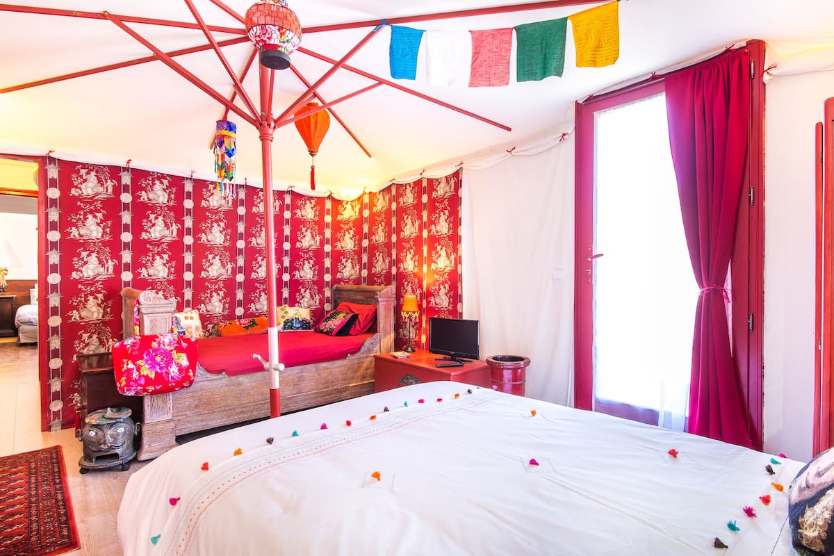A traditional room with a bed, a desk, and a television.
