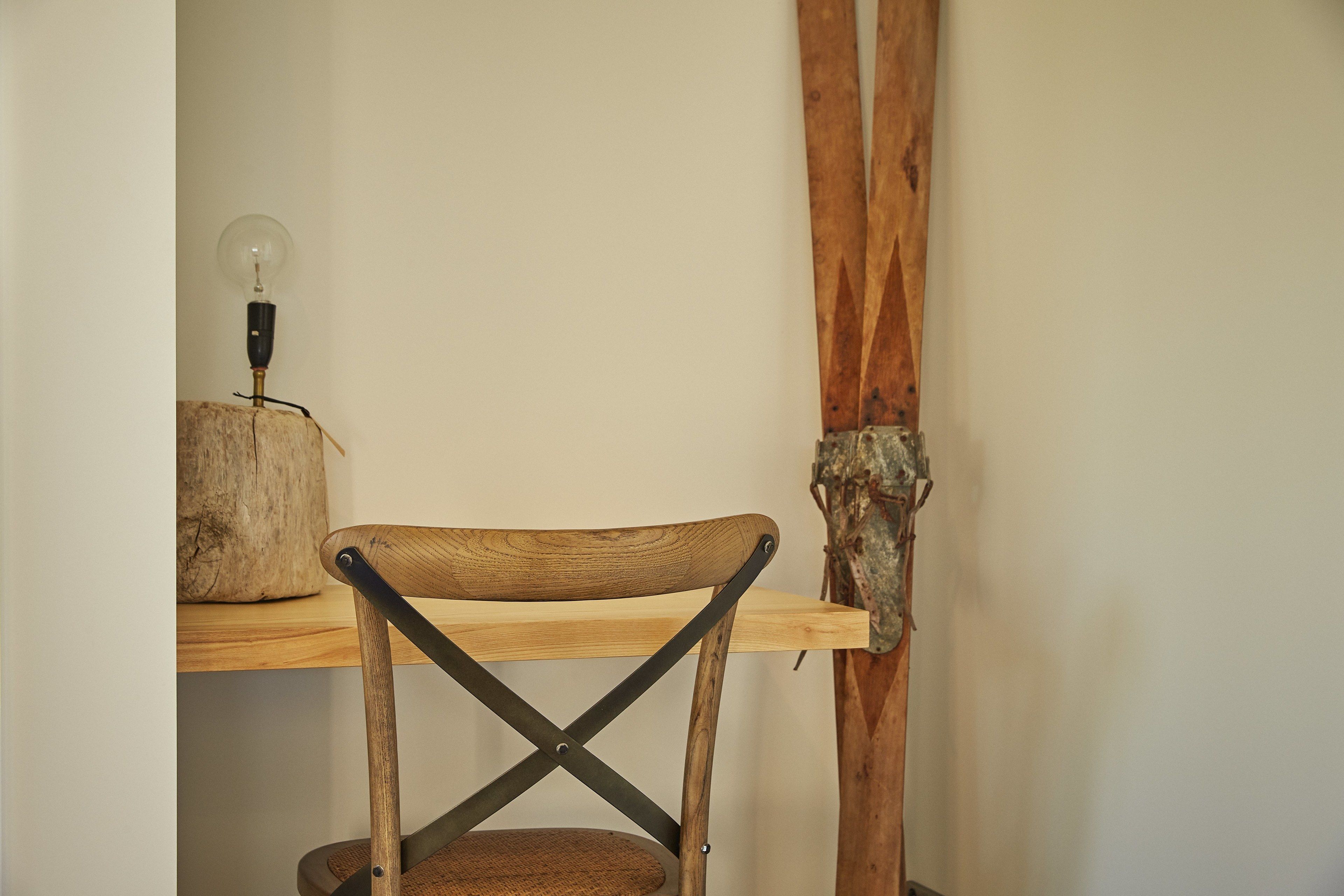 A wooden chair with a metal frame and a light bulb on a wooden shelf.