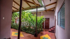 Um corredor coberto com teto de madeira, uma porta e uma janela à direita.