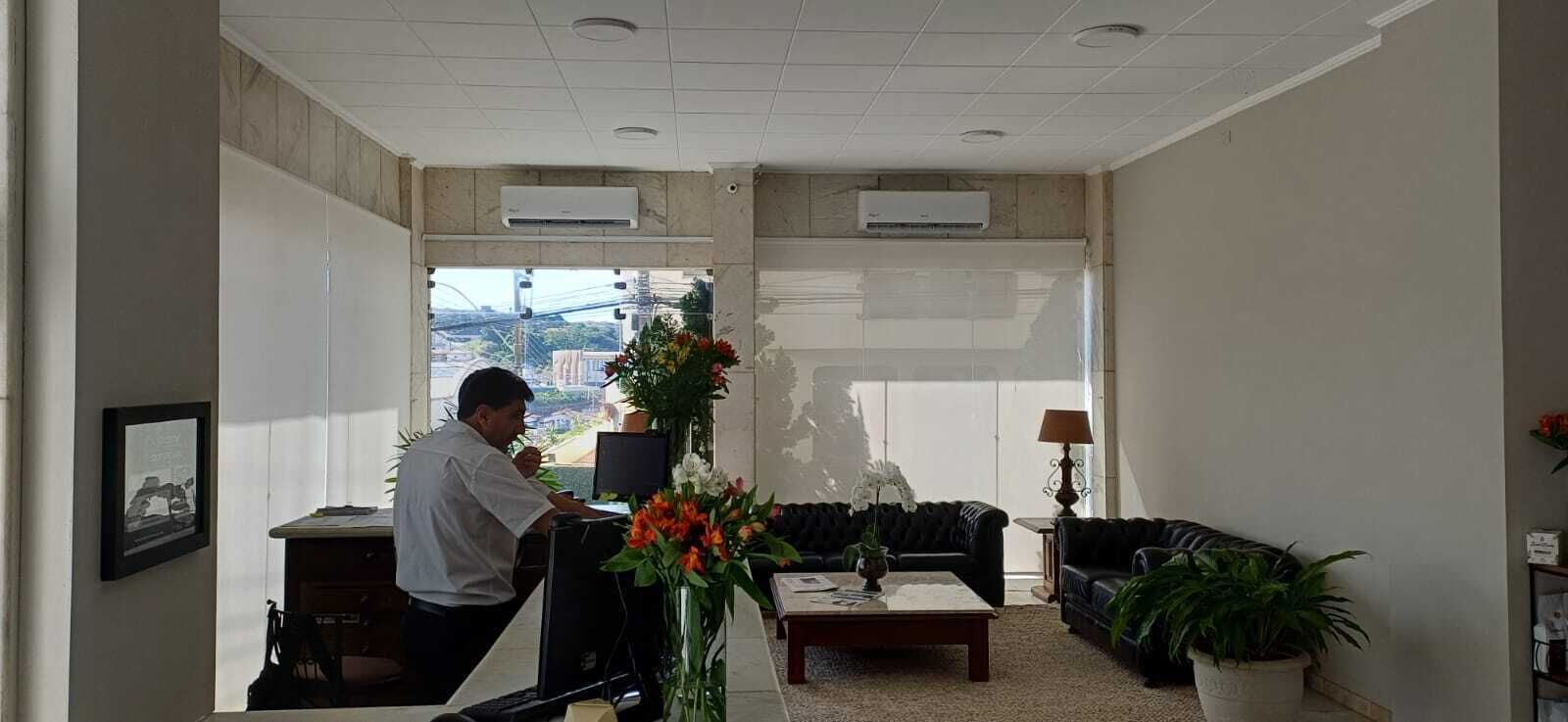 Un hall de hotel con una recepción, un sofá, una mesa de centro y una planta en maceta.