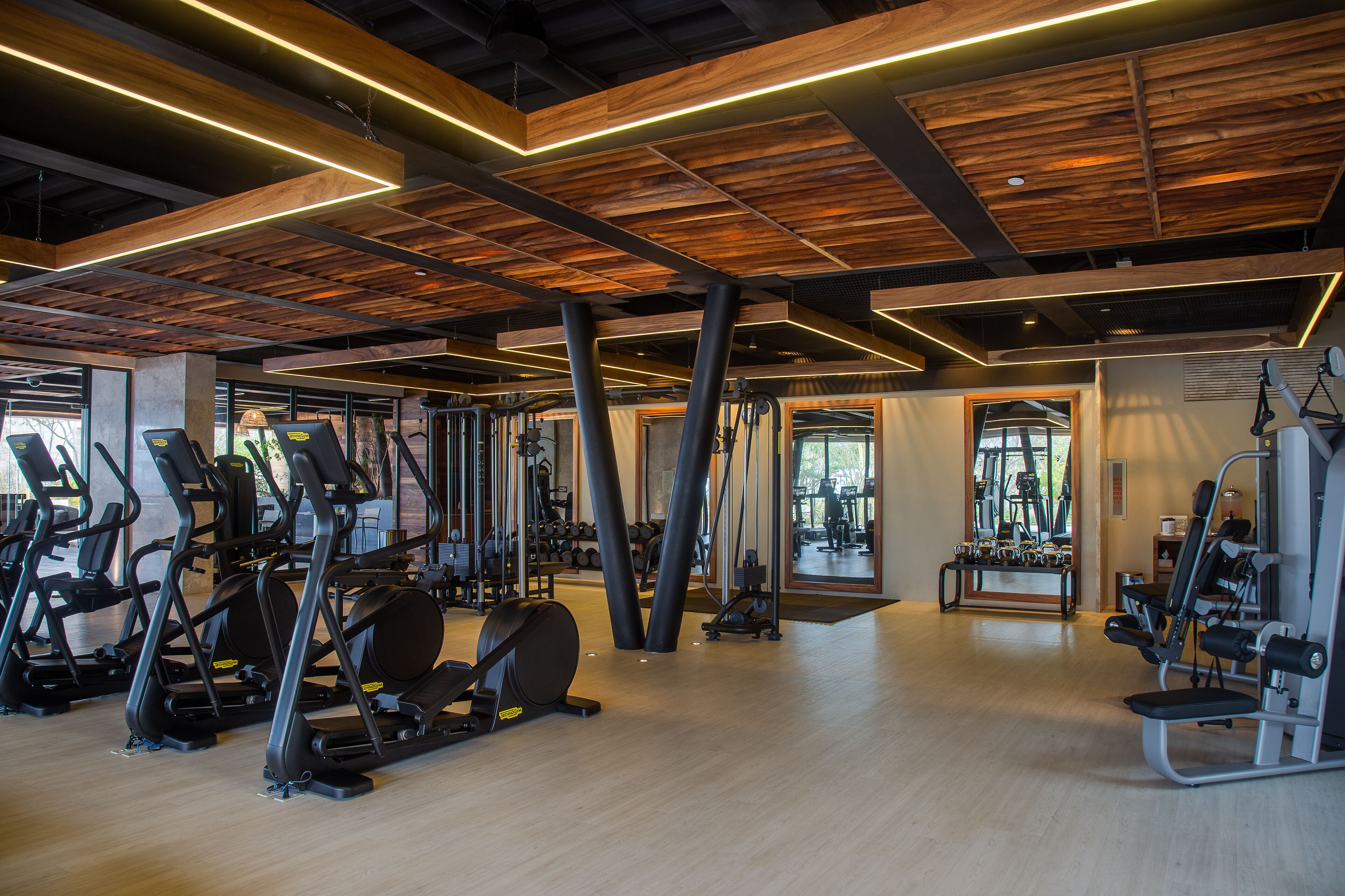 Ein Fitnessstudio mit Laufbändern, Crosstrainern und Gewichten.