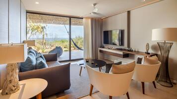 A modern living room with a sofa, chairs, a TV, and a large window with a view.