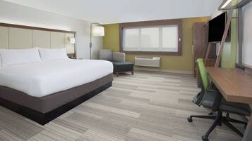 Habitación de hotel con una cama grande, un escritorio, una silla, un televisor y una ventana.