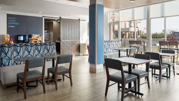 A modern cafe with seating areas, a coffee bar, and large windows offering views. - Holiday Inn Express and Suites West Memphis by IHG (West Memphis)