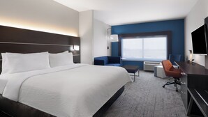 A modern hotel room with a large bed, a desk, a chair, and a TV. - Holiday Inn Express and Suites West Memphis by IHG (West Memphis)