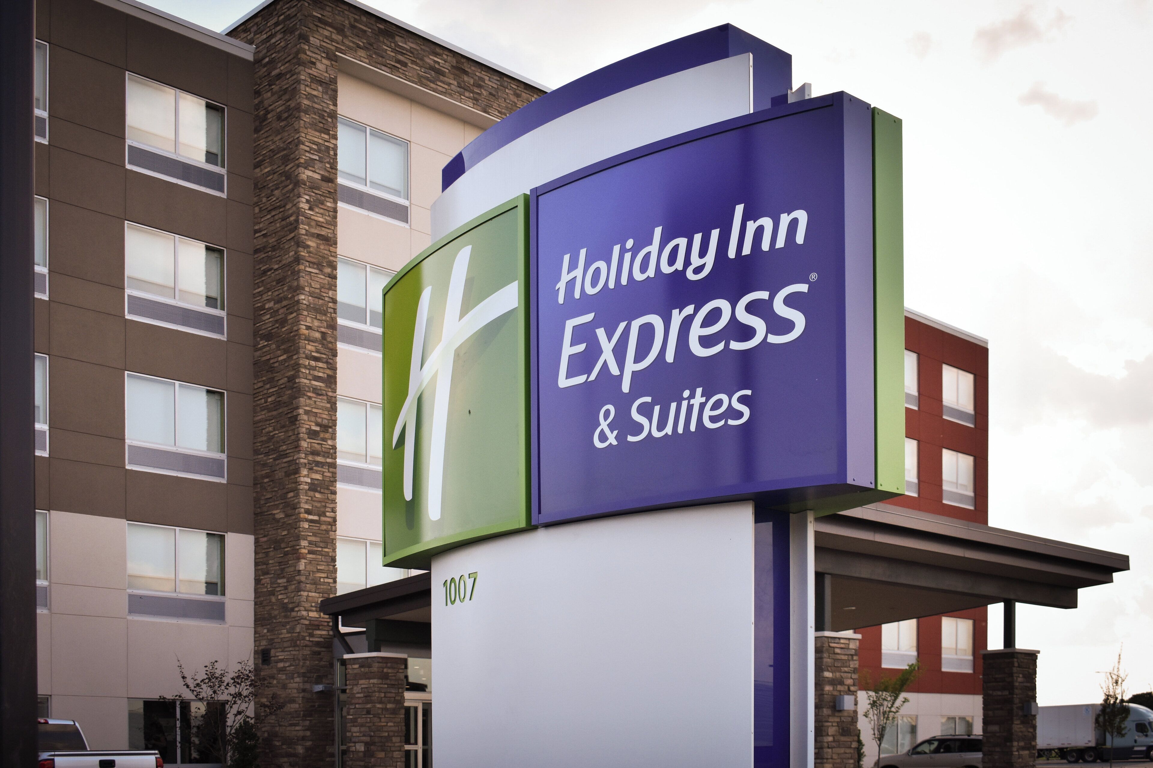 A Holiday Inn Express & Suites sign with a modern design, featuring a prominent logo and the name of the hotel.