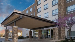 A modern hotel entrance with a covered walkway, stone pillars, and a glass door entrance. - Holiday Inn Express and Suites West Memphis by IHG (West Memphis)