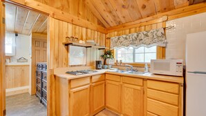 A wooden kitchen with a microwave, sink, and cabinets. - 'Wapiti' Allenspark Cabin Near Rocky Mountains! (Allenspark)