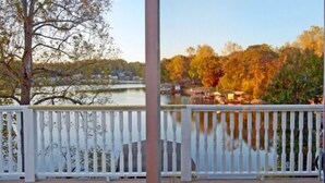 A view from a balcony with a white railing, overlooking a lake with boats and trees in autumn colors. - 5 o'clock Somewhere - Pool Table, Walking Distance to Portside Bar & Grill, Just Like New! (Moneta)